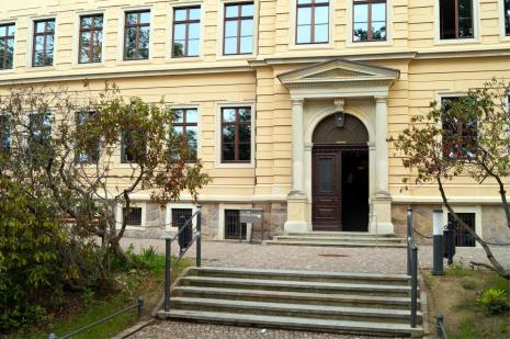 Schulgebäudefront mit offener Eingangstür